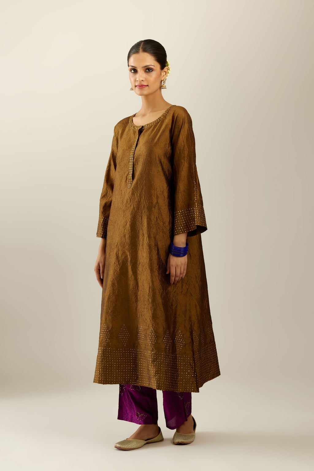 Golden olive silk hand crushed kurta set with concealed button placket neckline, highlighted with gold sequins heavy work at hem.