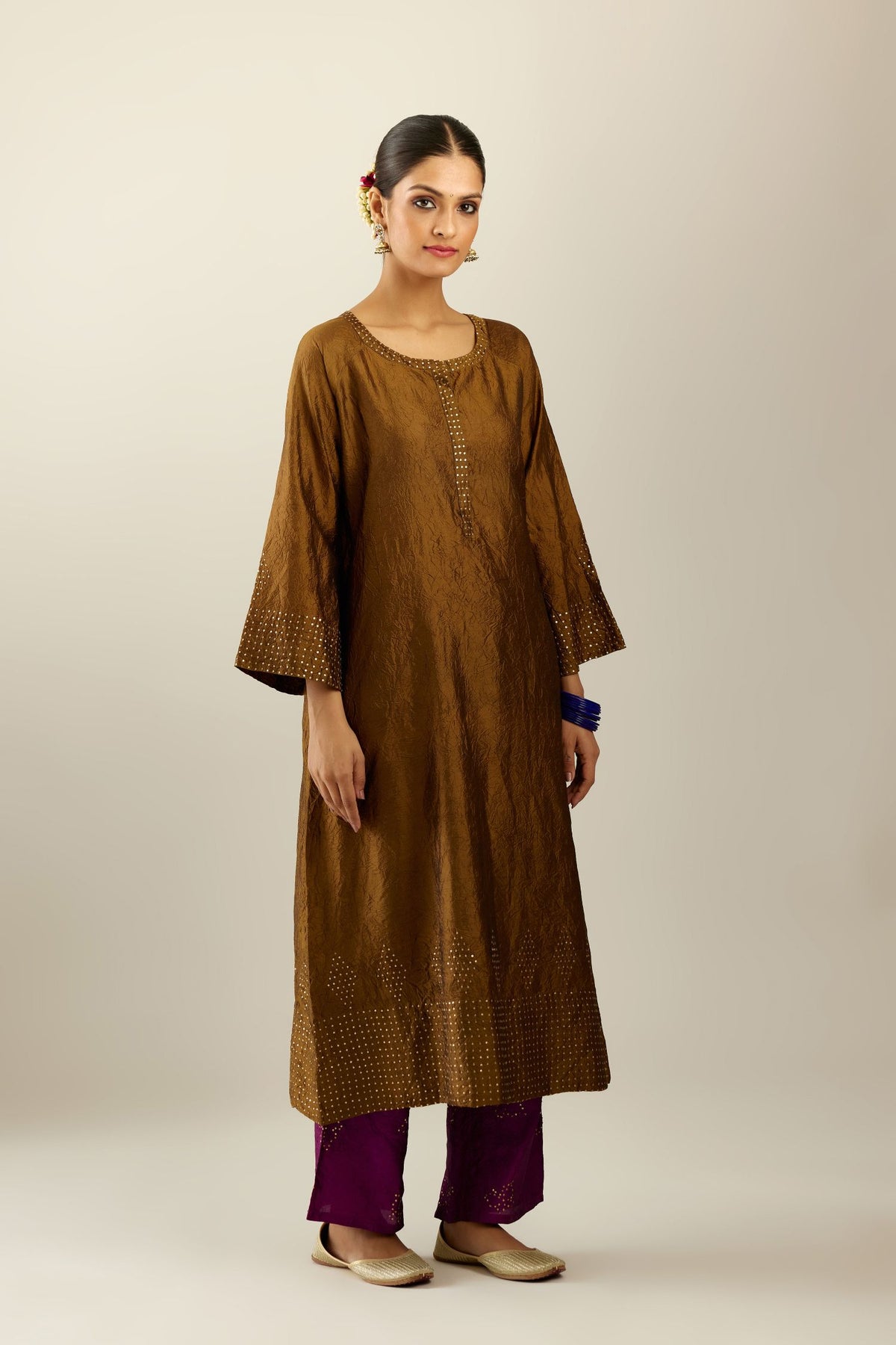 Golden olive silk hand crushed kurta set with concealed button placket neckline, highlighted with gold sequins heavy work at hem.