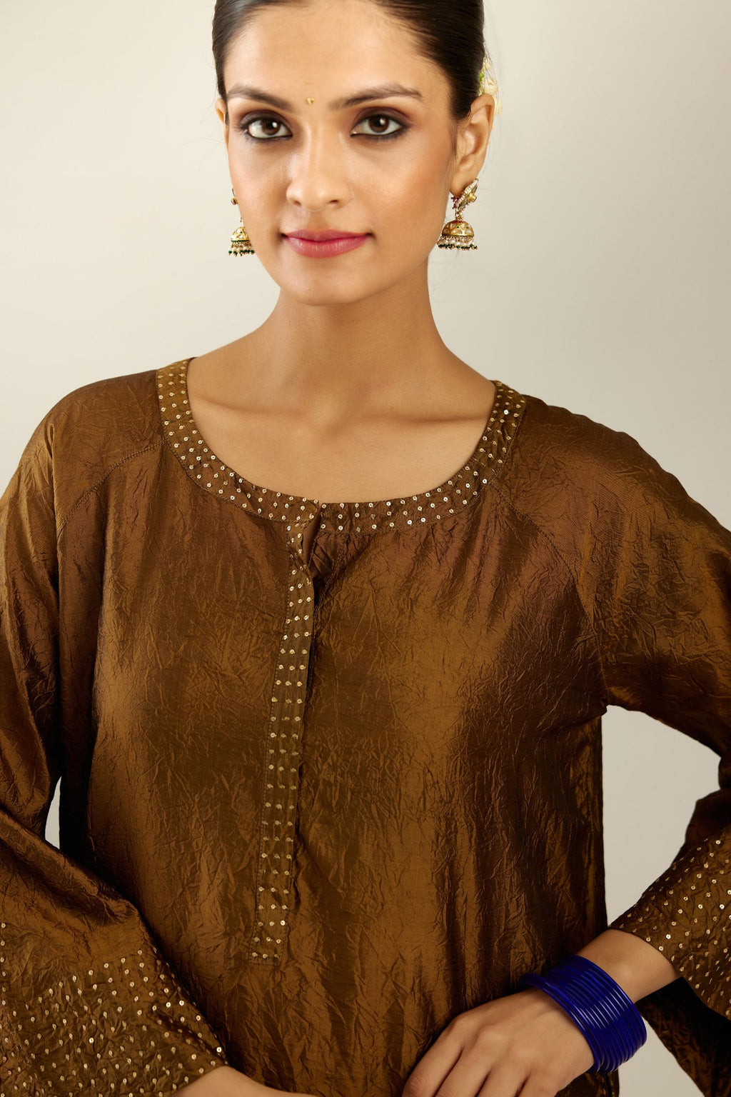 Golden olive silk hand crushed kurta set with concealed button placket neckline, highlighted with gold sequins heavy work at hem.