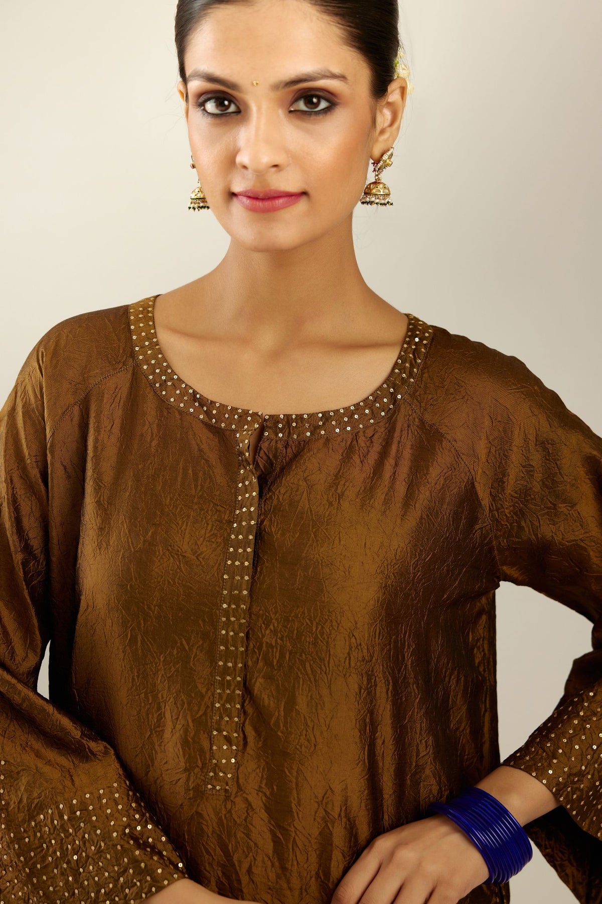 Golden olive silk hand crushed kurta set with concealed button placket neckline, highlighted with gold sequins heavy work at hem.