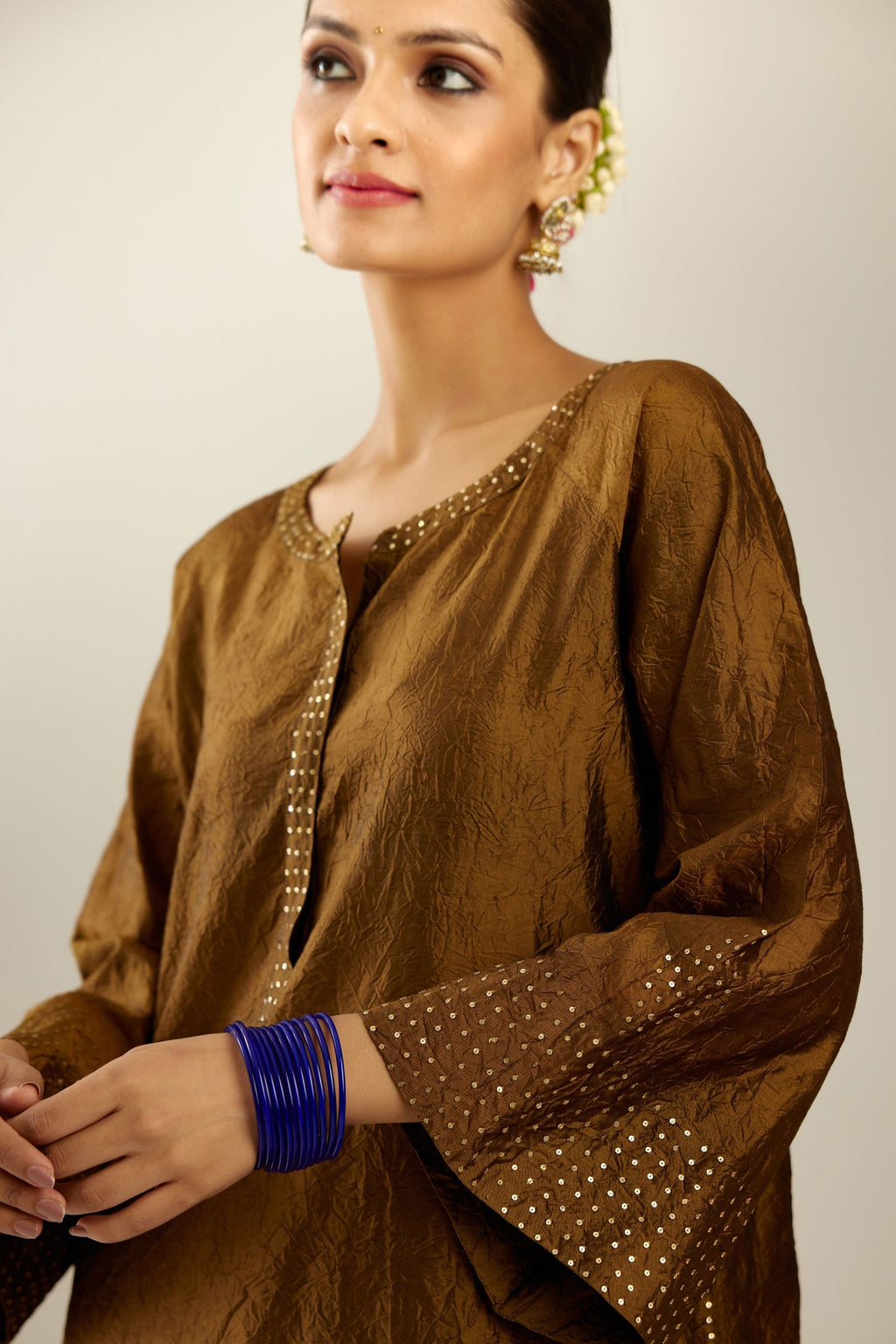 Golden olive silk hand crushed kurta set with concealed button placket neckline, highlighted with gold sequins heavy work at hem.
