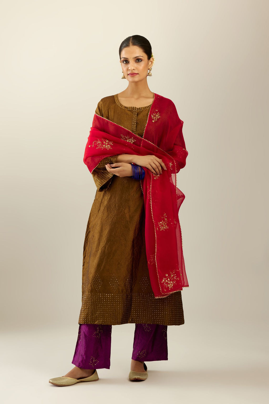 Golden olive silk hand crushed kurta set with concealed button placket neckline, highlighted with gold sequins heavy work at hem.