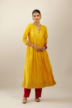 Yellow hand crushed silk kurta set with wavy empire waistline, gathers at waist and all-over gold sequins work detailing.