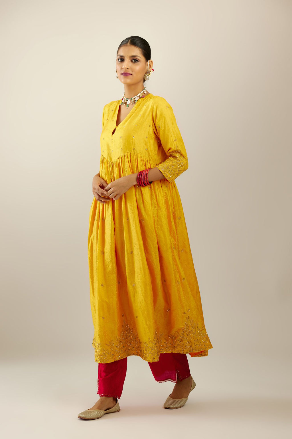 Yellow hand crushed silk kurta set with wavy empire waistline, gathers at waist and all-over gold sequins work detailing.