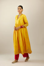 Yellow hand crushed silk kurta set with wavy empire waistline, gathers at waist and all-over gold sequins work detailing.