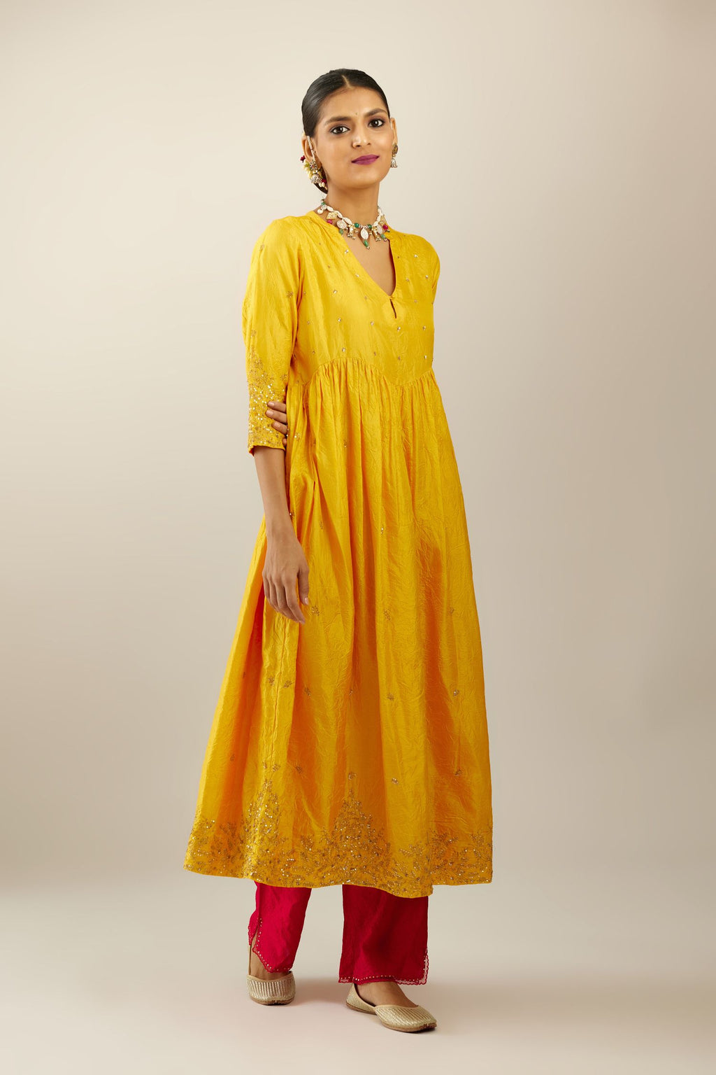 Yellow hand crushed silk kurta set with wavy empire waistline, gathers at waist and all-over gold sequins work detailing.