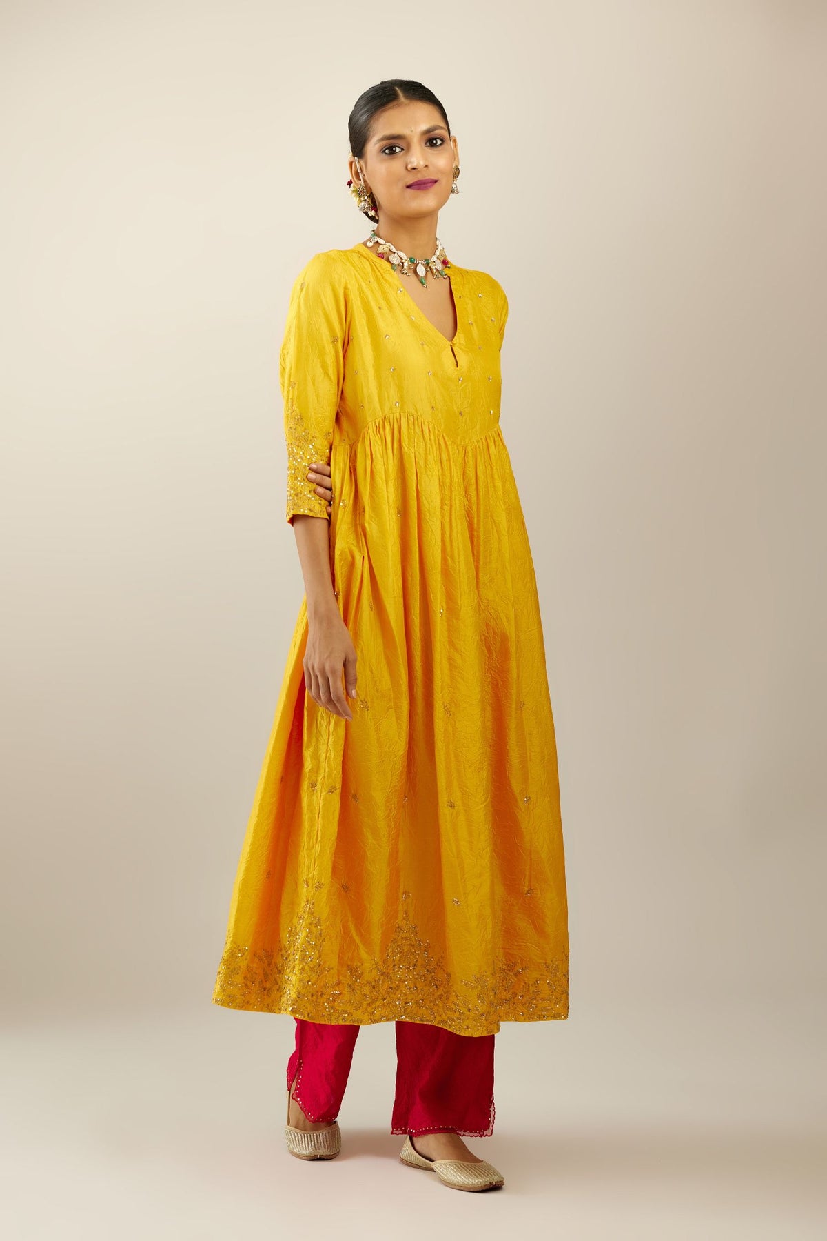 Yellow hand crushed silk kurta set with wavy empire waistline, gathers at waist and all-over gold sequins work detailing.