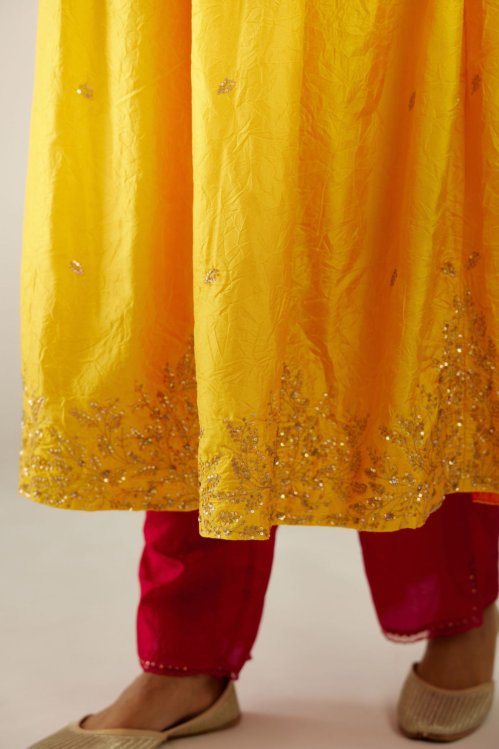 Yellow hand crushed silk kurta set with wavy empire waistline, gathers at waist and all-over gold sequins work detailing.