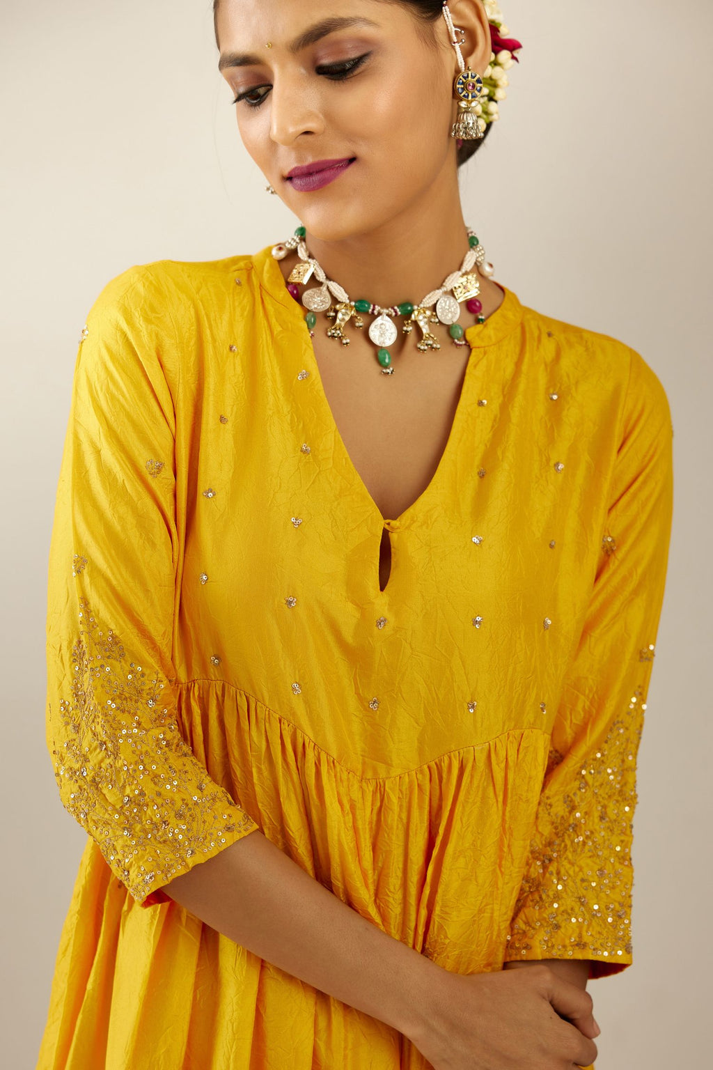 Yellow hand crushed silk kurta set with wavy empire waistline, gathers at waist and all-over gold sequins work detailing.