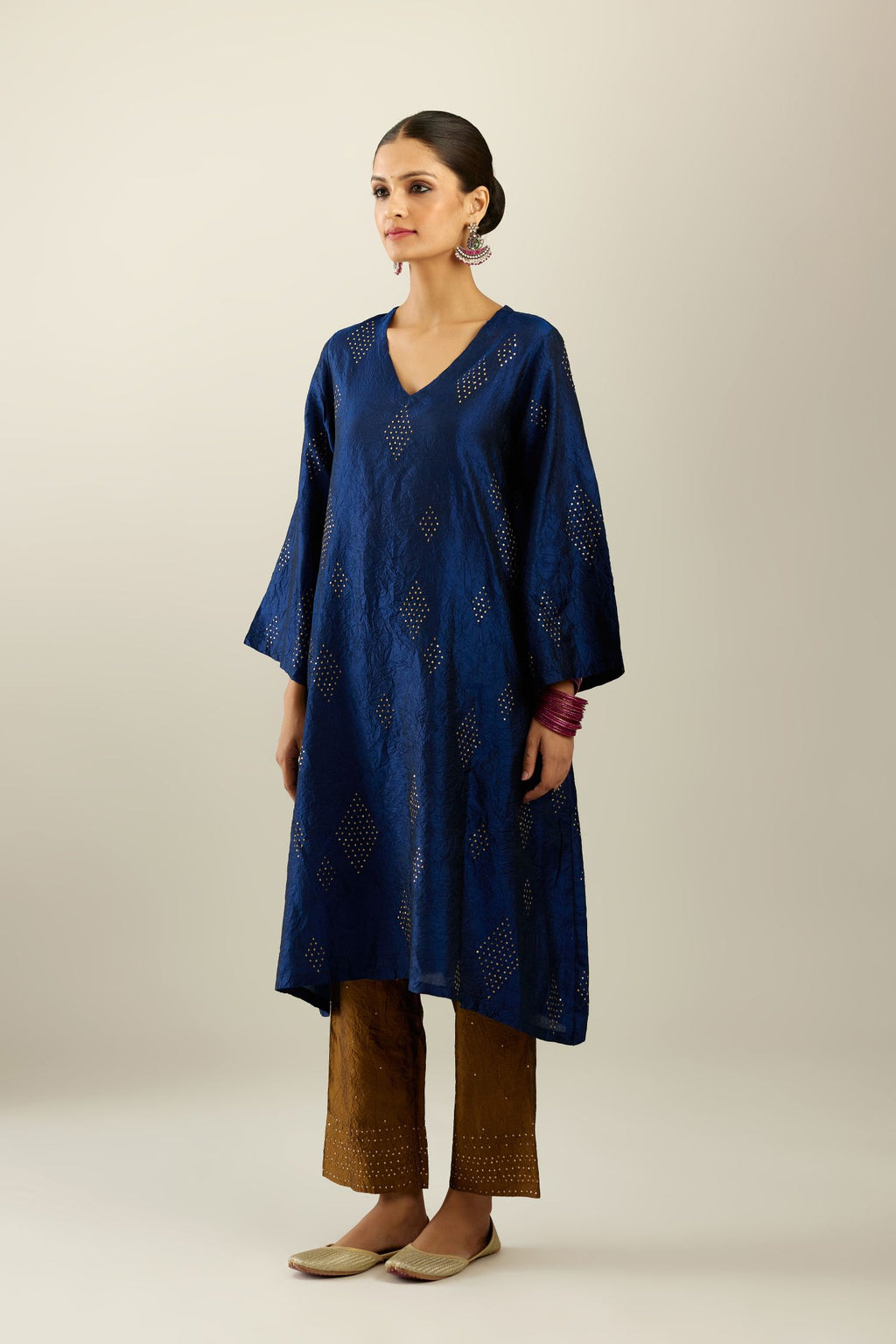 Navy blue silk hand crushed easy fit straight hem kurta, highlighted with all-over gold sequins in diamond shape, paired with golden olive hand crushed pure silk straight pants with gold sequins at hem in horizontal lines formation and side pockets.