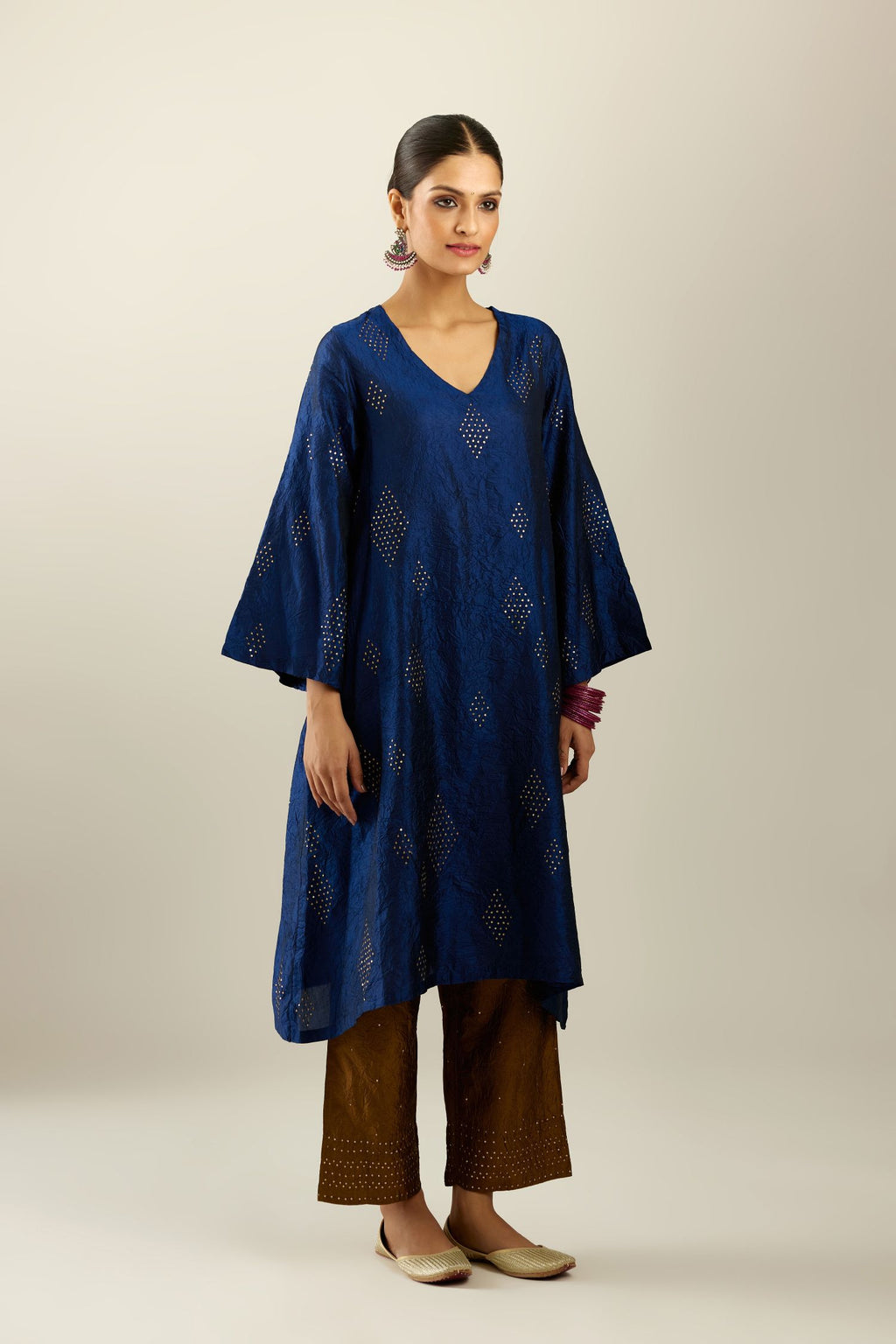 Navy blue silk hand crushed easy fit straight hem kurta, highlighted with all-over gold sequins in diamond shape, paired with golden olive hand crushed pure silk straight pants with gold sequins at hem in horizontal lines formation and side pockets.