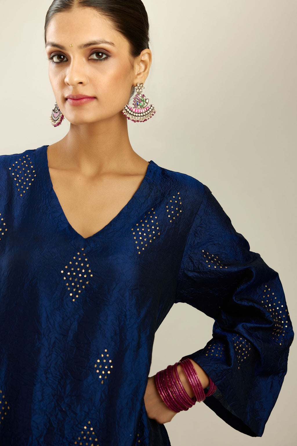 Navy blue silk hand crushed easy fit straight hem kurta, highlighted with all-over gold sequins in diamond shape, paired with golden olive hand crushed pure silk straight pants with gold sequins at hem in horizontal lines formation and side pockets.