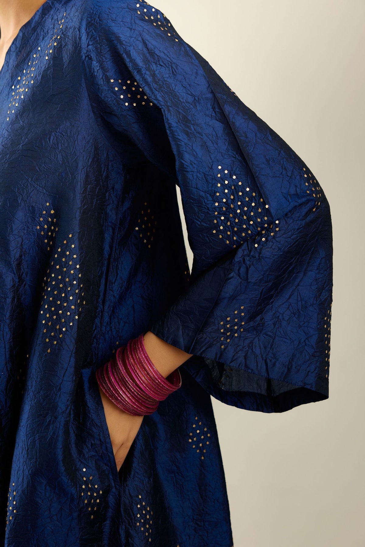 Navy blue silk hand crushed easy fit straight hem kurta, highlighted with all-over gold sequins in diamond shape, paired with golden olive hand crushed pure silk straight pants with gold sequins at hem in horizontal lines formation and side pockets.