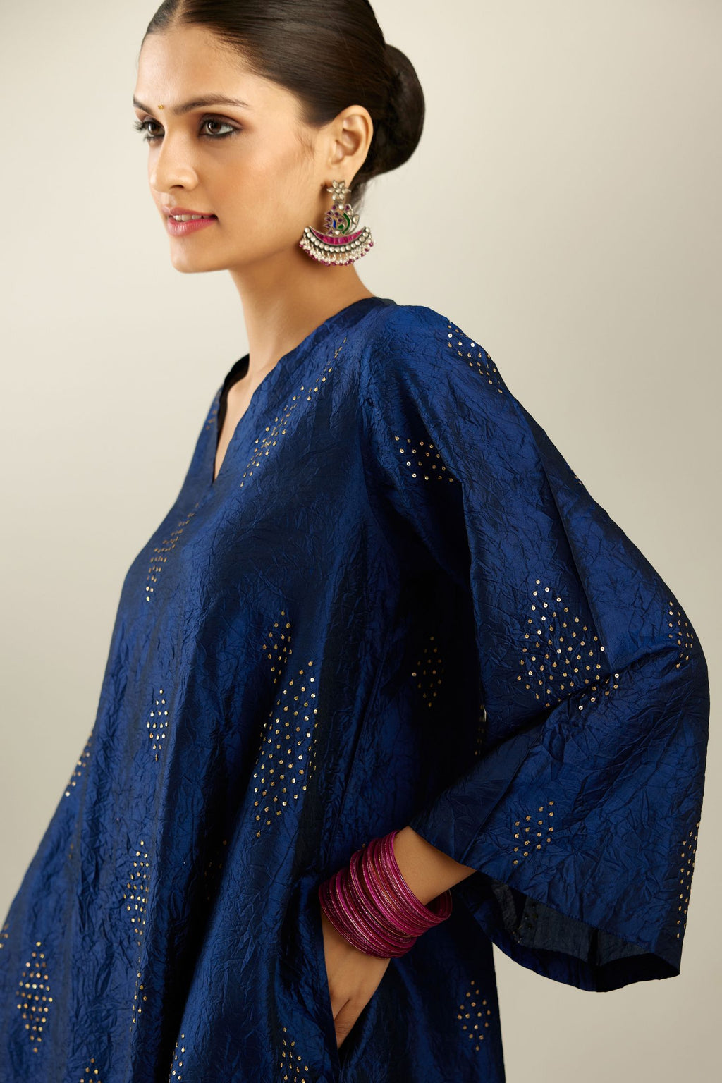 Navy blue silk hand crushed easy fit straight hem kurta, highlighted with all-over gold sequins in diamond shape, paired with golden olive hand crushed pure silk straight pants with gold sequins at hem in horizontal lines formation and side pockets.
