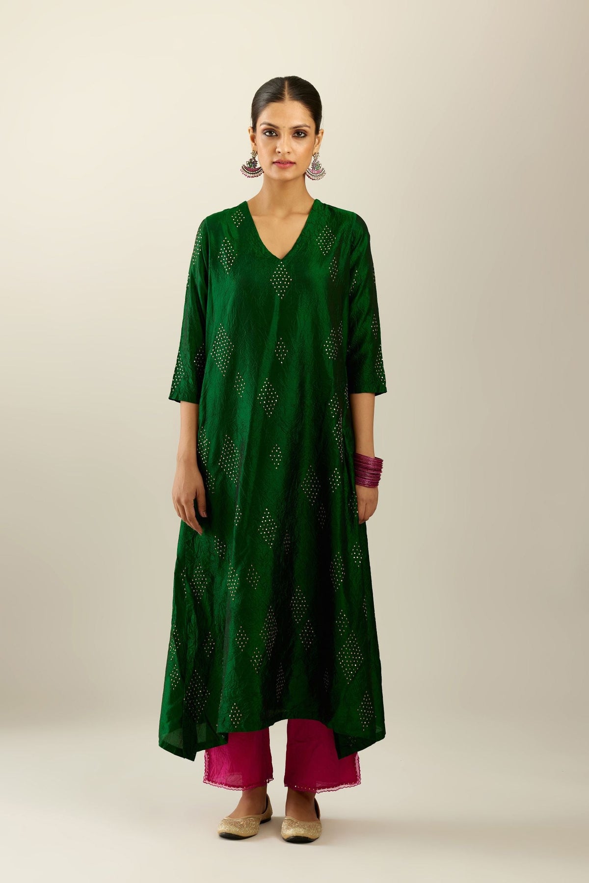 Dark green silk hand crushed A-line kurta with asymmetric hem, highlighted with all-over gold sequins diamonds, paired with raspberry  pants with scalloped and embroidered organza at edges and detailed with a single line of sequins at hem