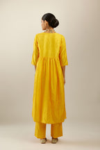 Deep yellow silk hand crushed V neck gathered kurta set, highlighted with gold sequins and embroidered scalloped organza at edges.