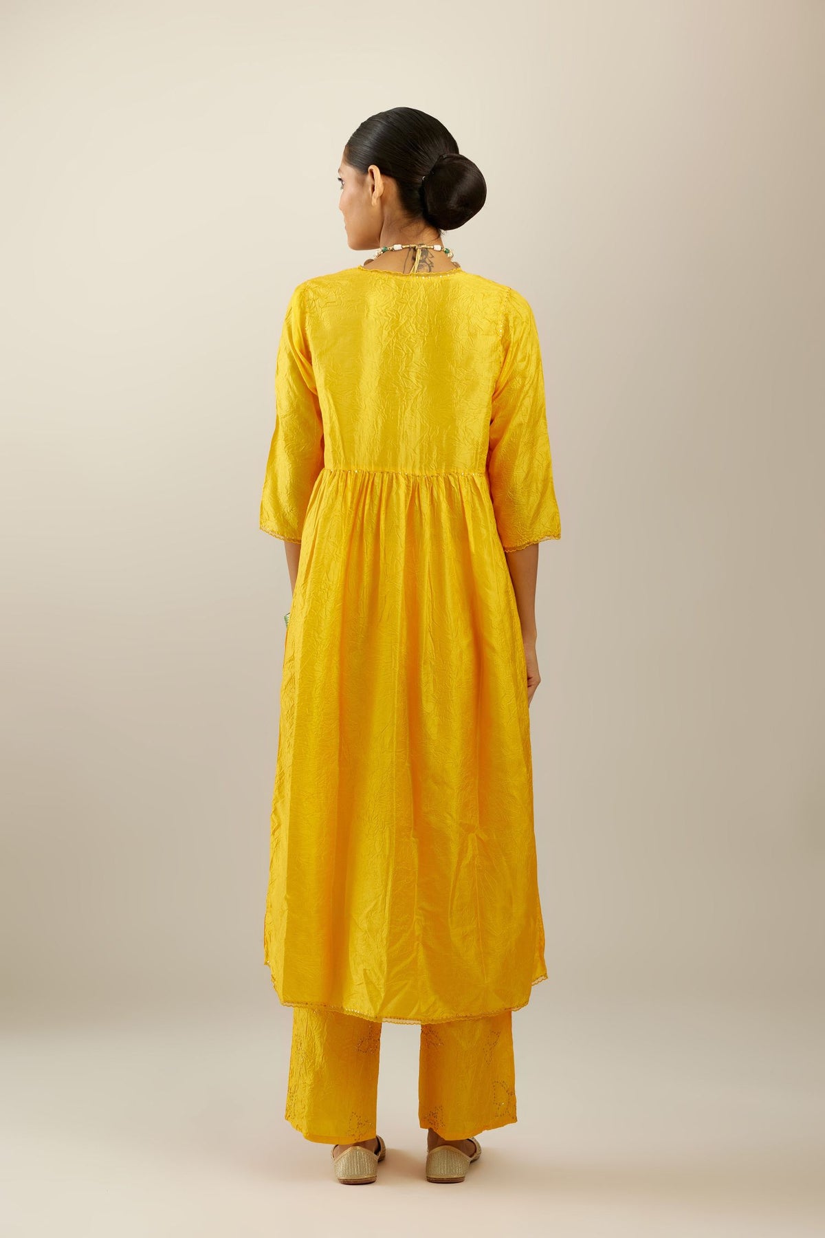 Deep yellow silk hand crushed V neck gathered kurta set, highlighted with gold sequins and embroidered scalloped organza at edges.