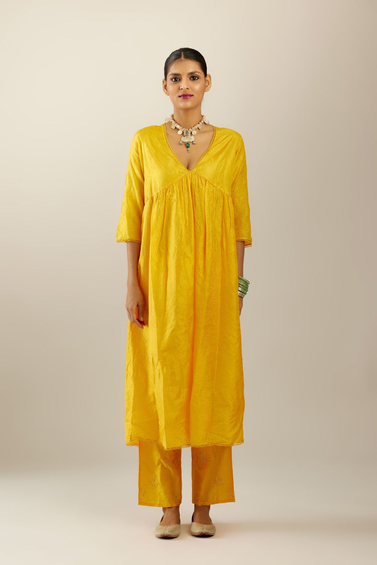 Deep yellow silk hand crushed V neck gathered kurta set, highlighted with gold sequins and embroidered scalloped organza at edges.
