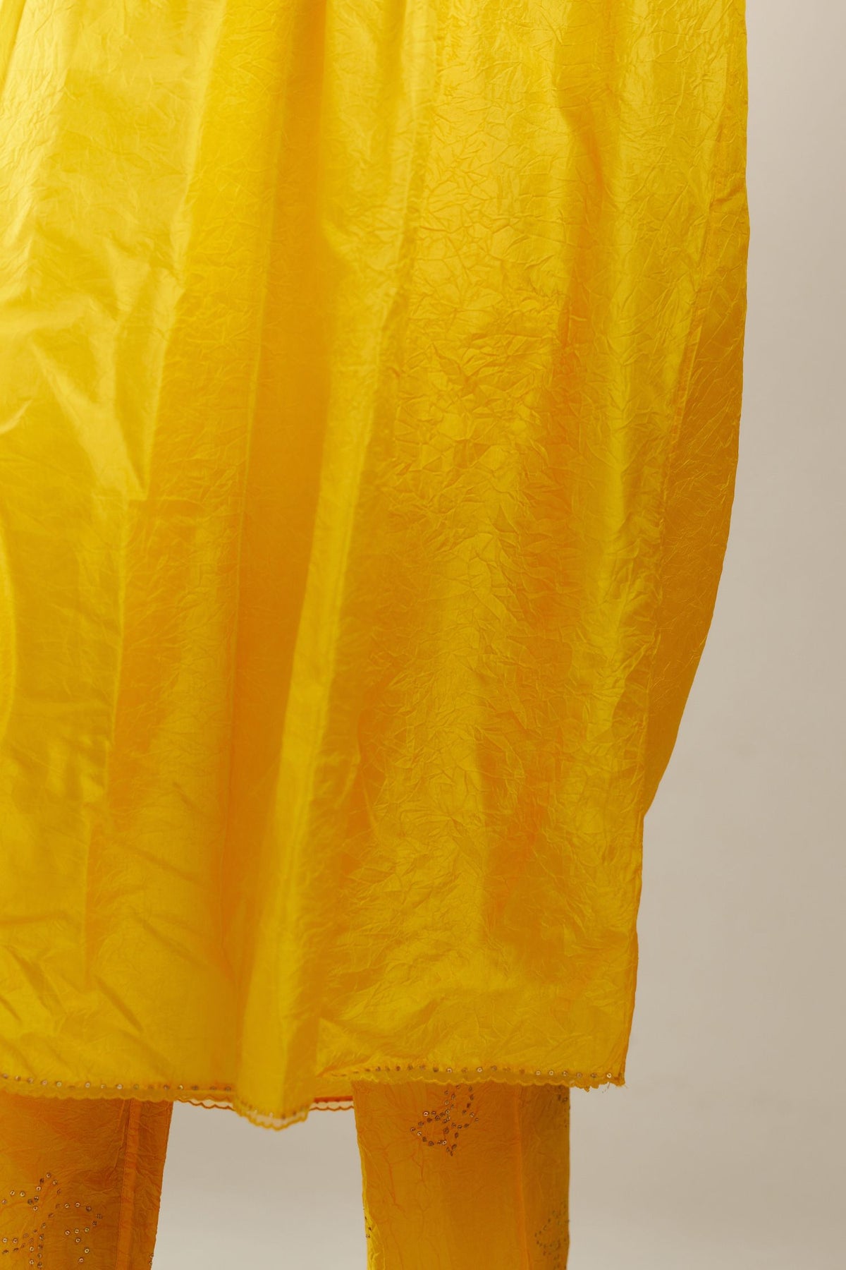 Deep yellow silk hand crushed V neck gathered kurta set, highlighted with gold sequins and embroidered scalloped organza at edges.