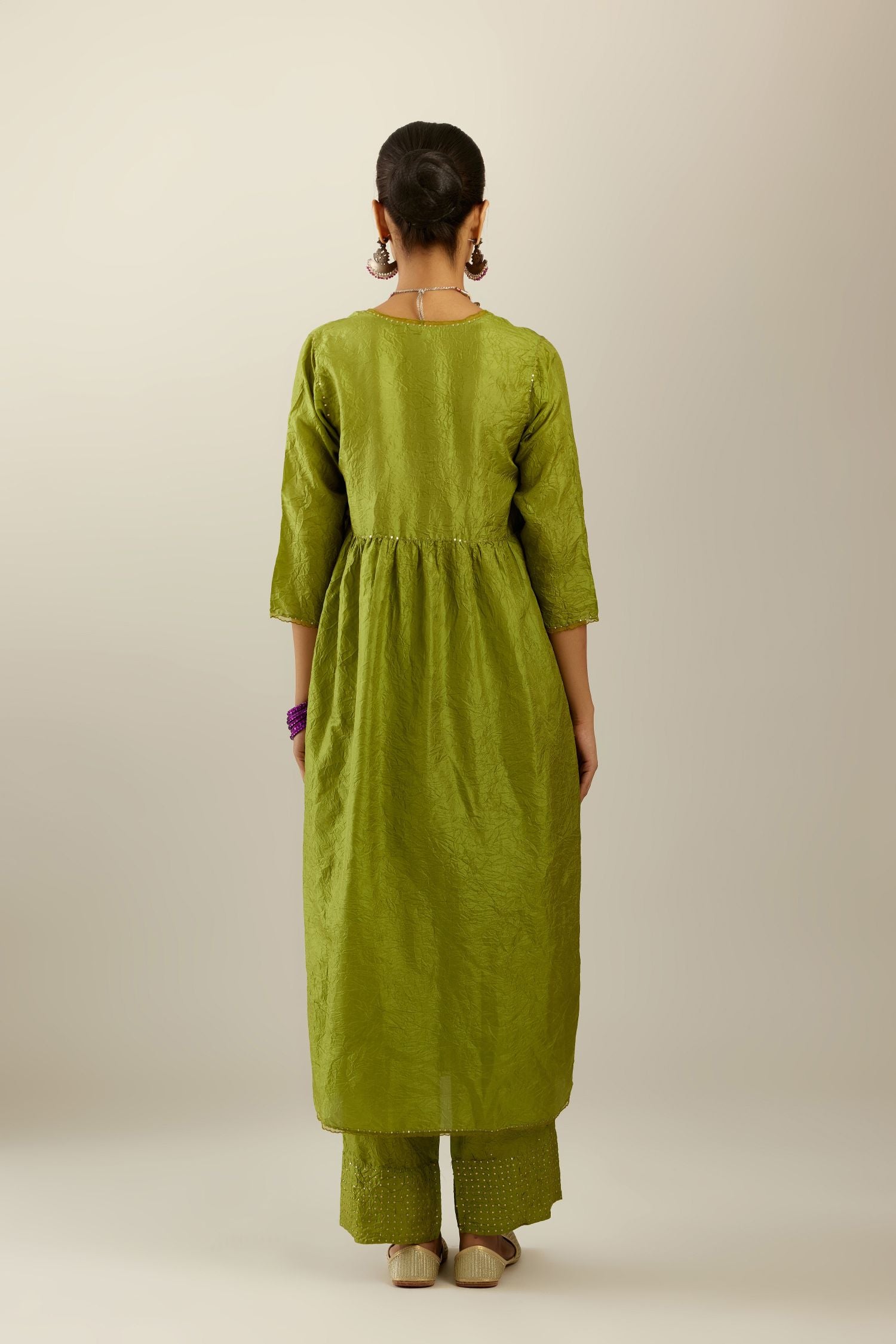 Apple green silk hand crushed V neck gathered kurta set, highlighted with gold sequins and embroidered scalloped organza at edges.