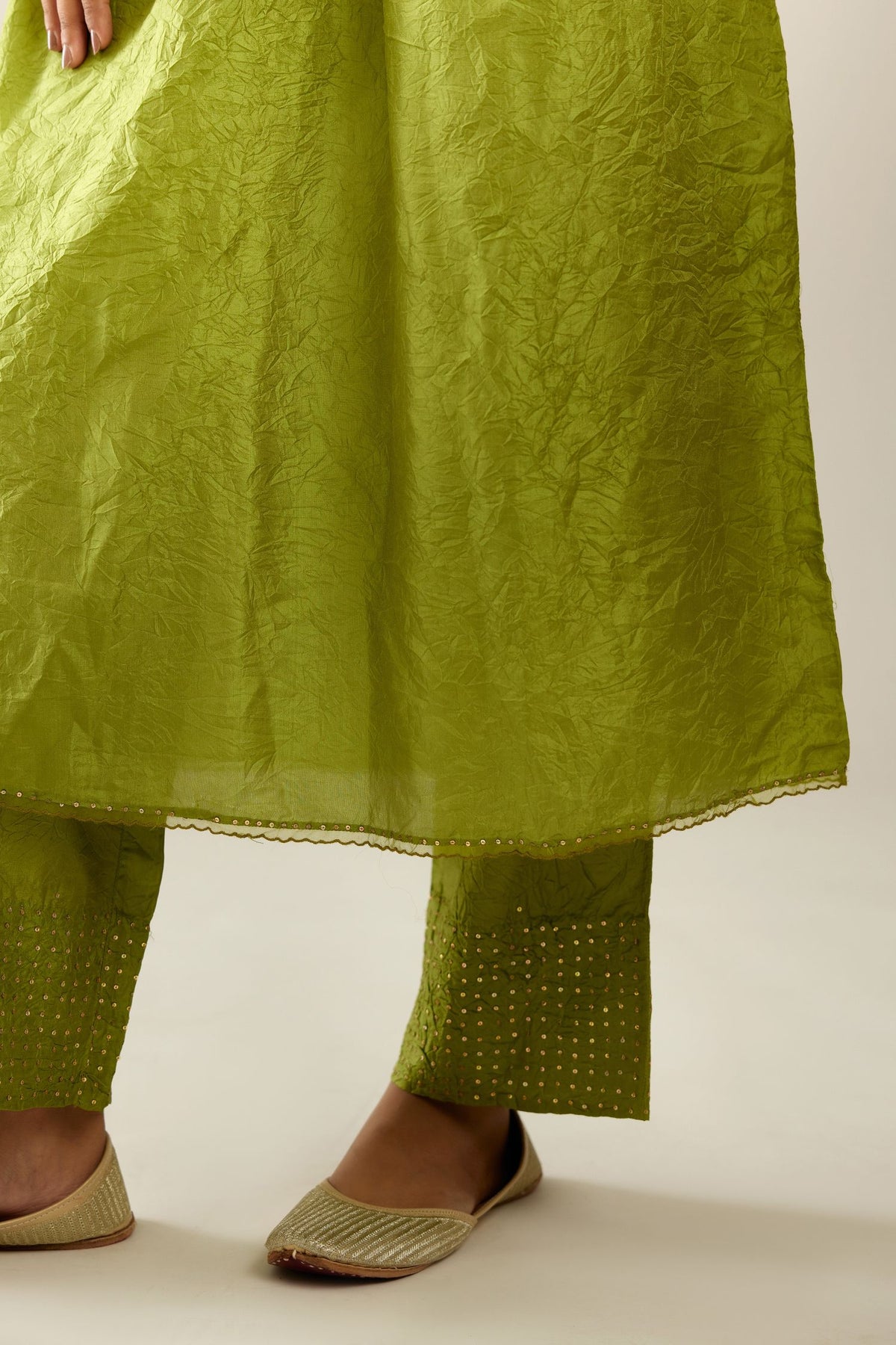 Apple green silk hand crushed V neck gathered kurta set, highlighted with gold sequins and embroidered scalloped organza at edges.