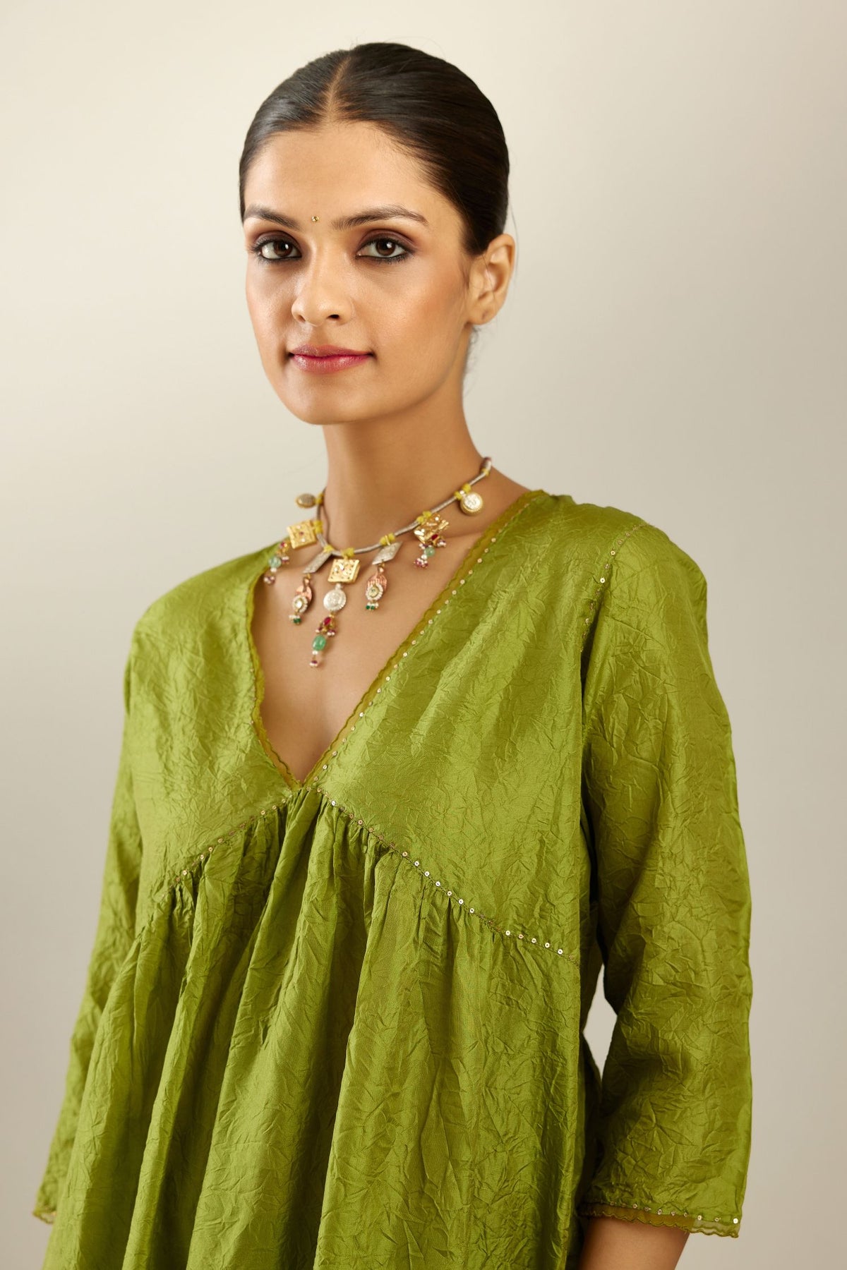 Apple green silk hand crushed V neck gathered kurta set, highlighted with gold sequins and embroidered scalloped organza at edges.