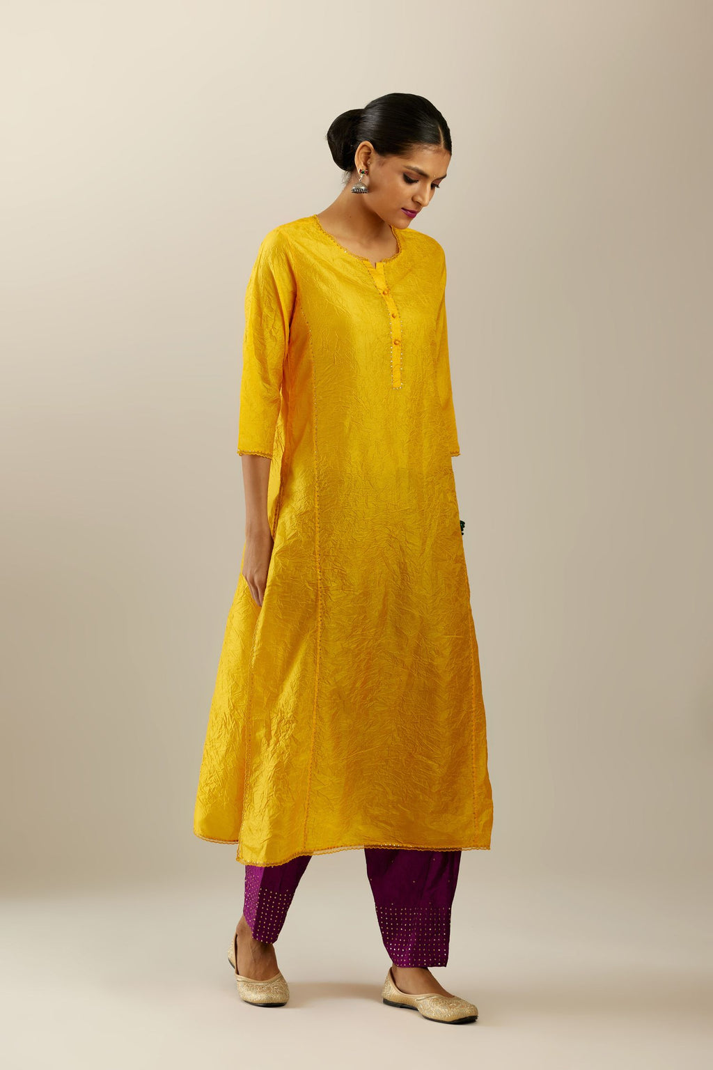 Silk hand crushed kurta set with concealed button placket neckline, highlighted with sequins and scalloped organza at edges.