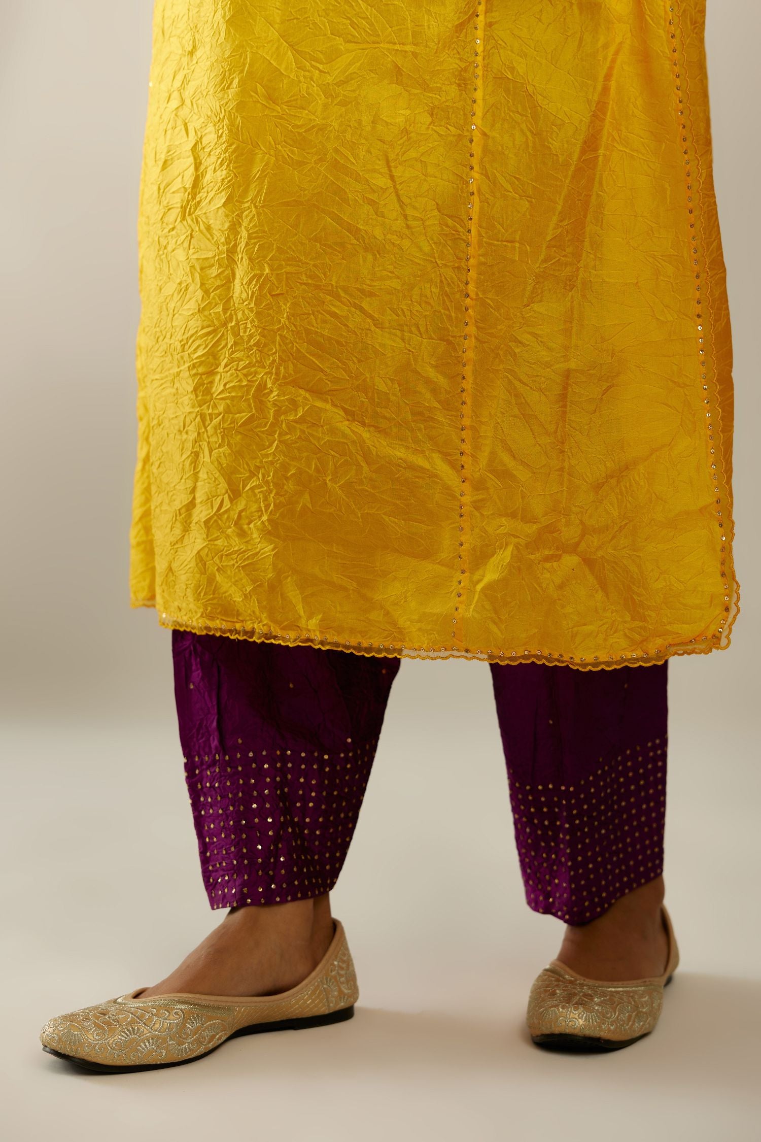 Silk hand crushed kurta set with concealed button placket neckline, highlighted with sequins and scalloped organza at edges.