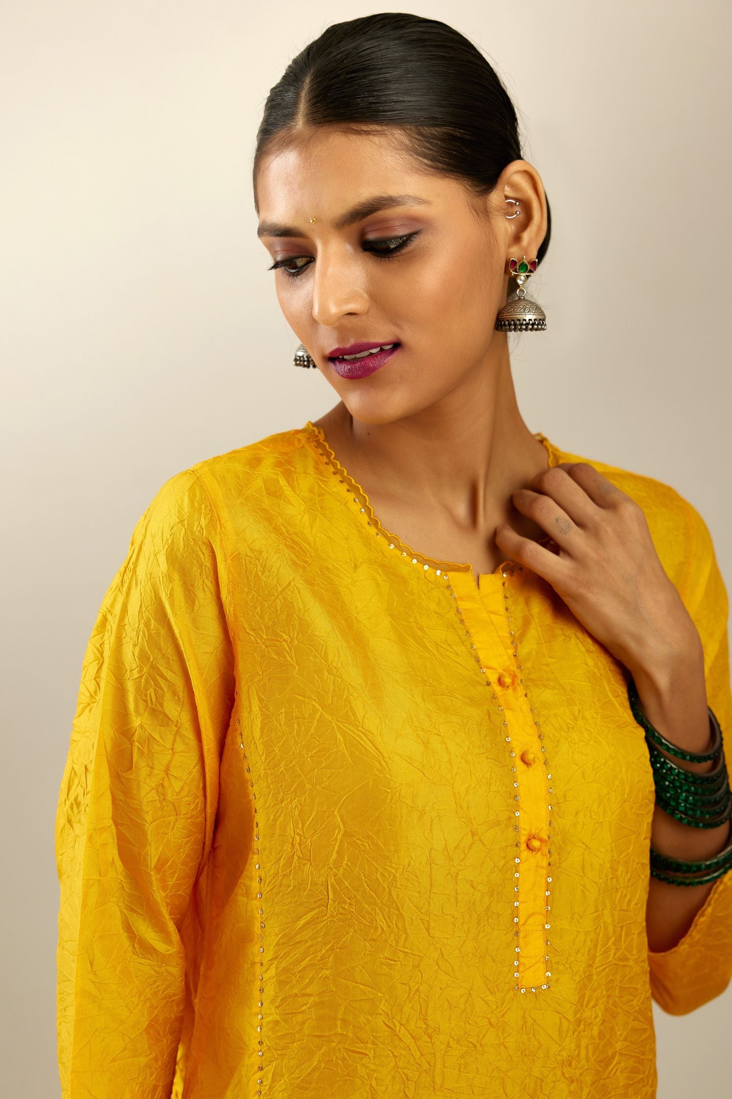 Silk hand crushed kurta set with concealed button placket neckline, highlighted with sequins and scalloped organza at edges.