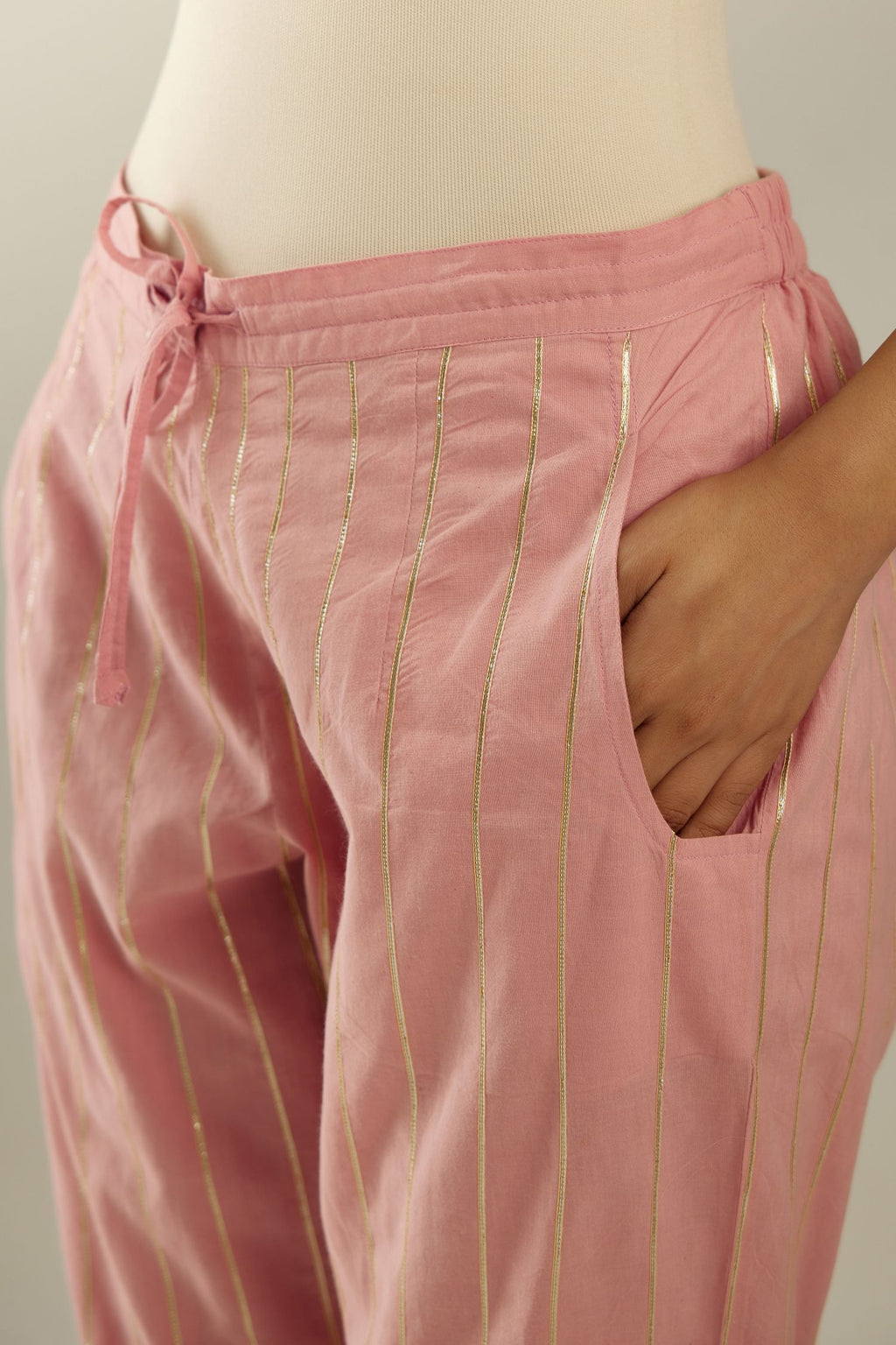 Pink cotton straight pants with all-over gold gota lines and zari embroidery at hem.