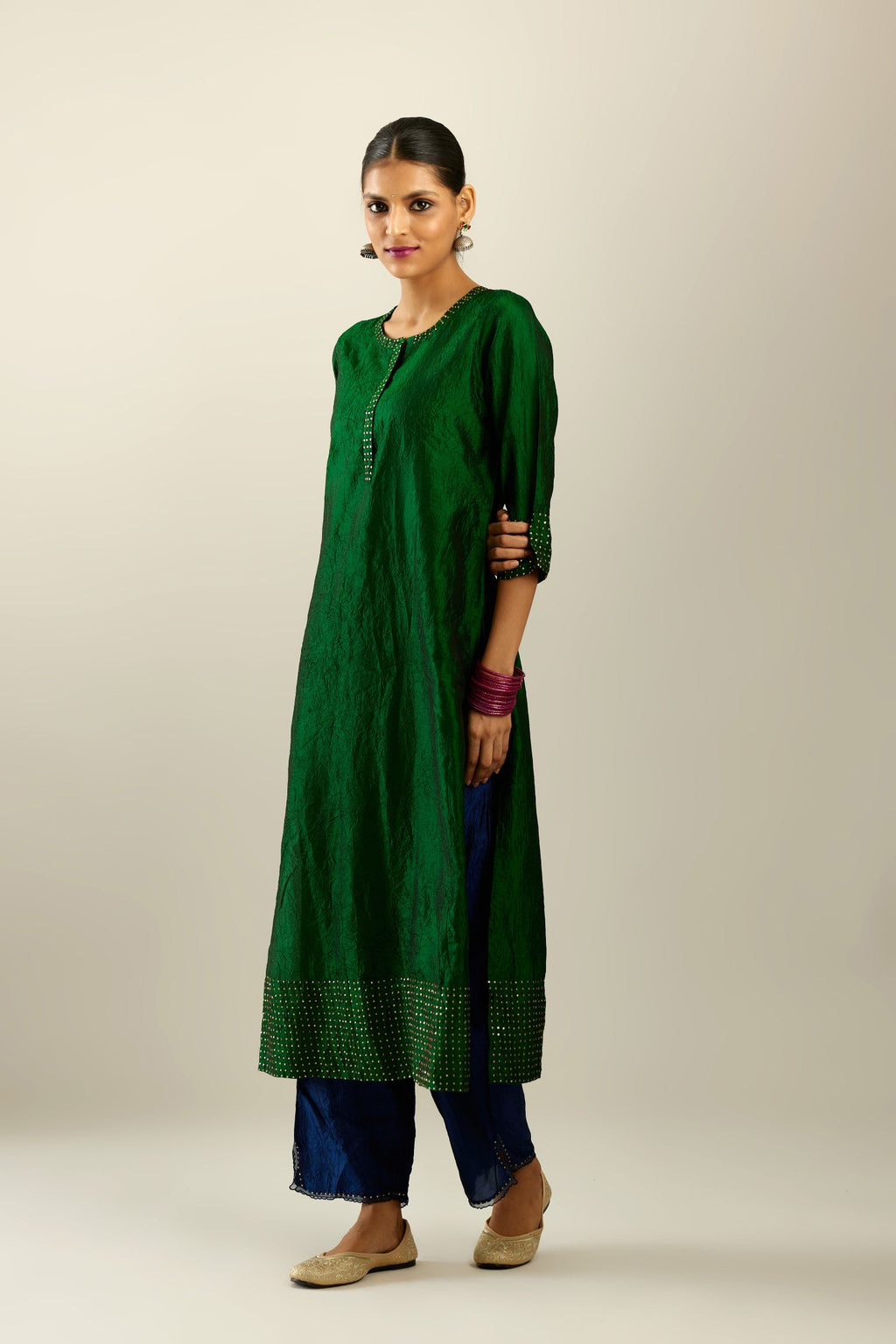 Dark green silk hand crushed kurta set with concealed button placket neckline, highlighted with gold sequins.