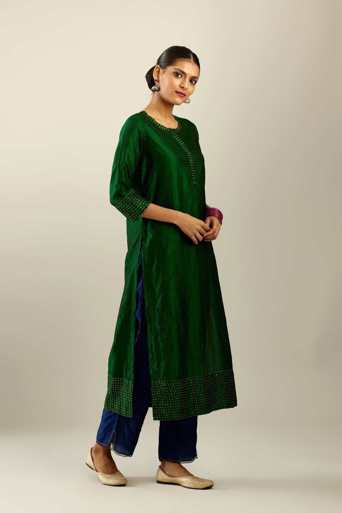 Dark green silk hand crushed kurta set with concealed button placket neckline, highlighted with gold sequins.