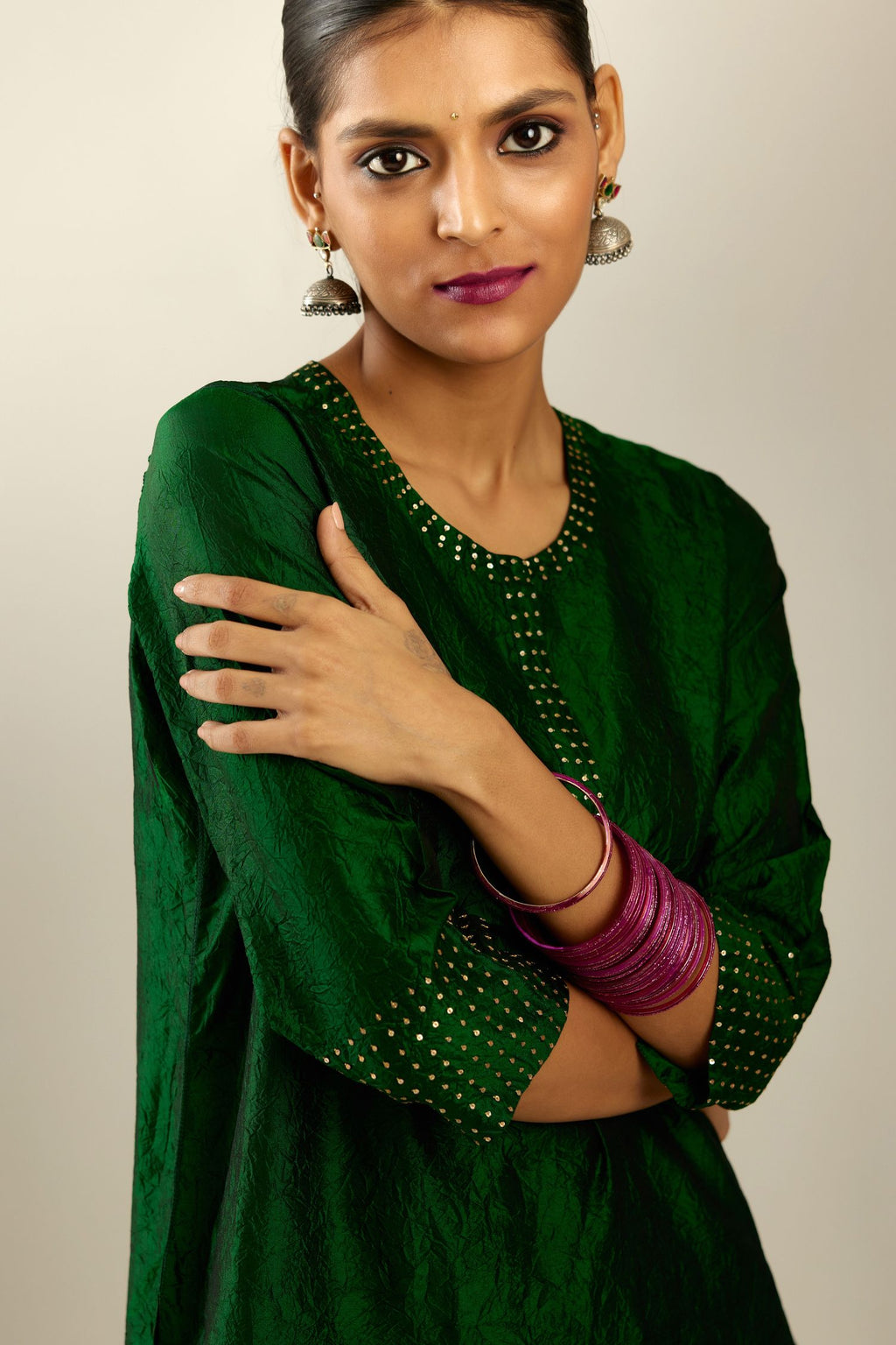 Dark green silk hand crushed kurta set with concealed button placket neckline, highlighted with gold sequins.