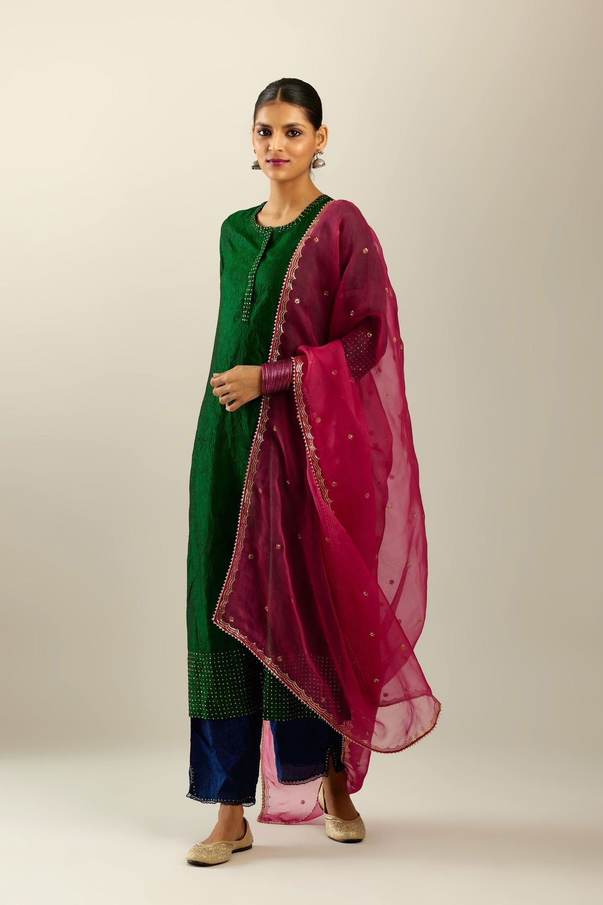 Dark green silk hand crushed kurta set with concealed button placket neckline, highlighted with gold sequins.