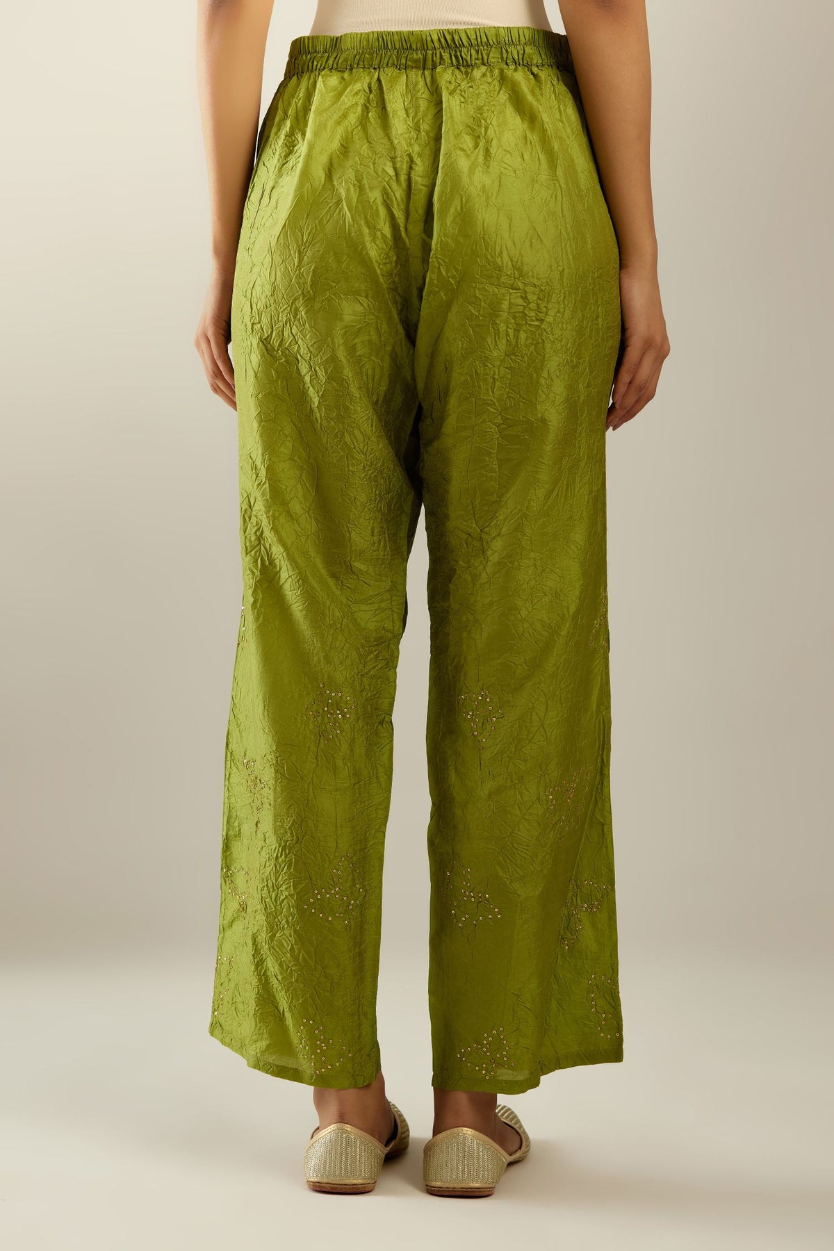 Apple green crushed silk pants with side pockets and assorted sequined butterflies till mid-calf length.