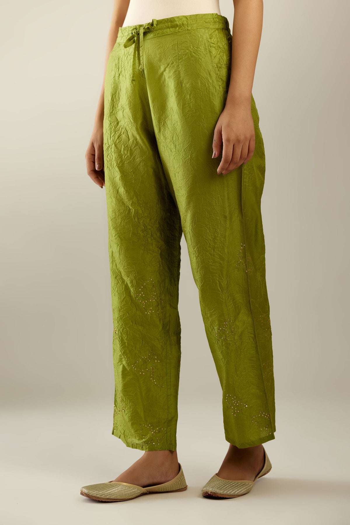 Apple green crushed silk pants with side pockets and assorted sequined butterflies till mid-calf length.