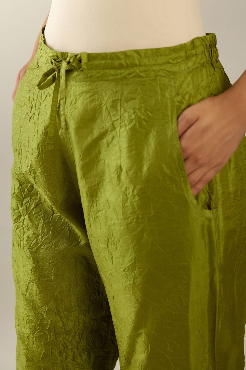 Apple green crushed silk pants with side pockets and assorted sequined butterflies till mid-calf length.