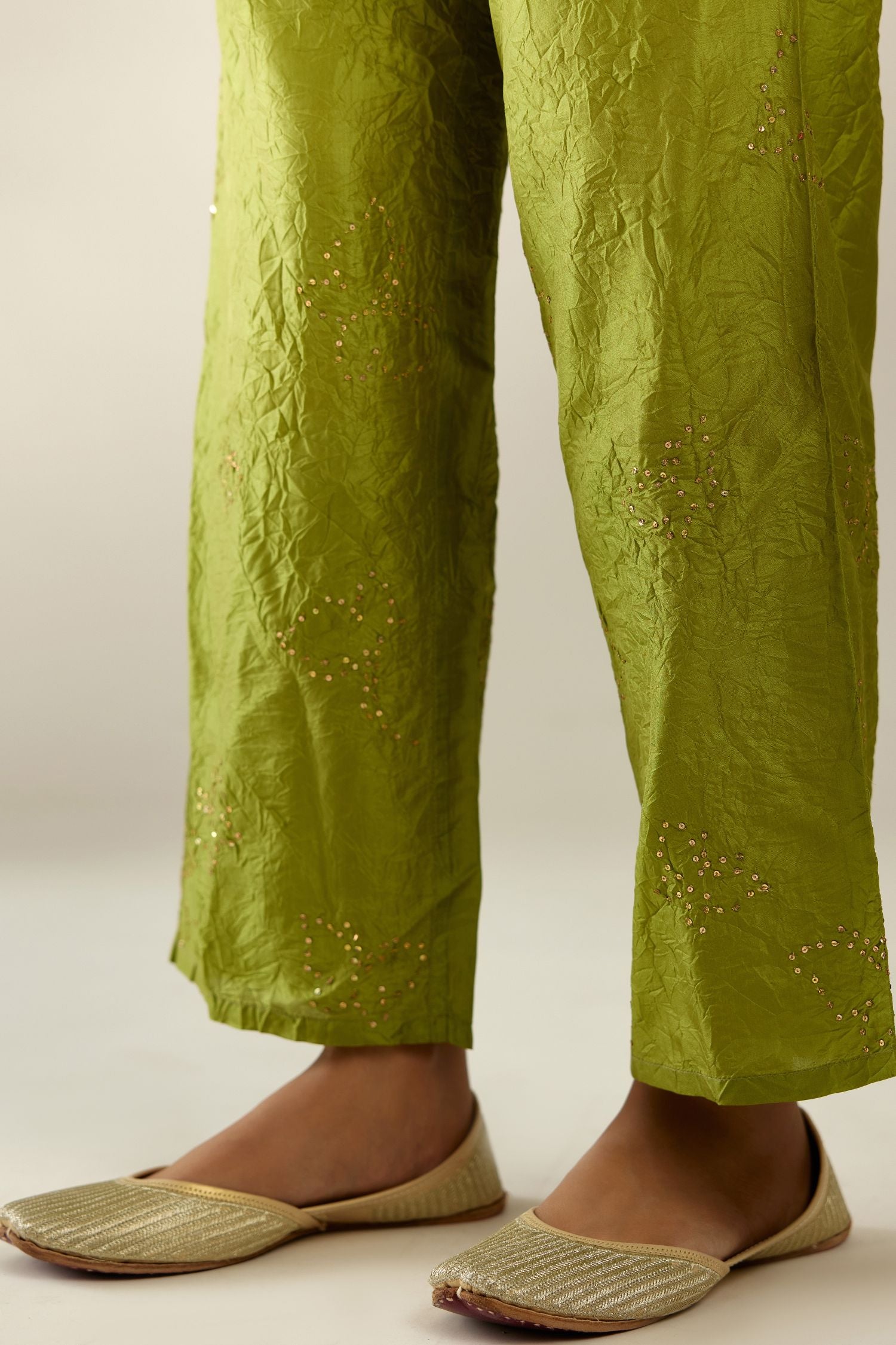 Apple green crushed silk pants with side pockets and assorted sequined butterflies till mid-calf length.