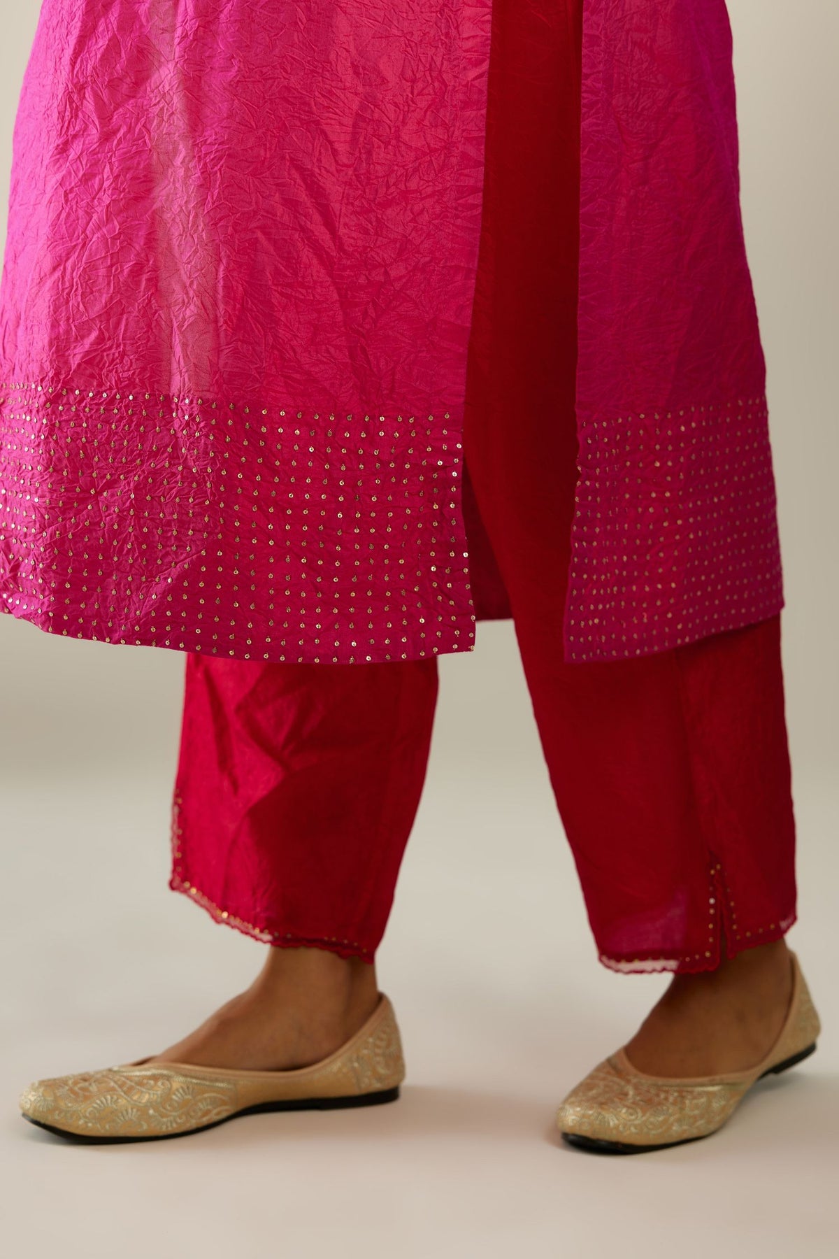 Raspberry silk hand crushed kurta set with concealed button placket neckline, highlighted with gold sequins.