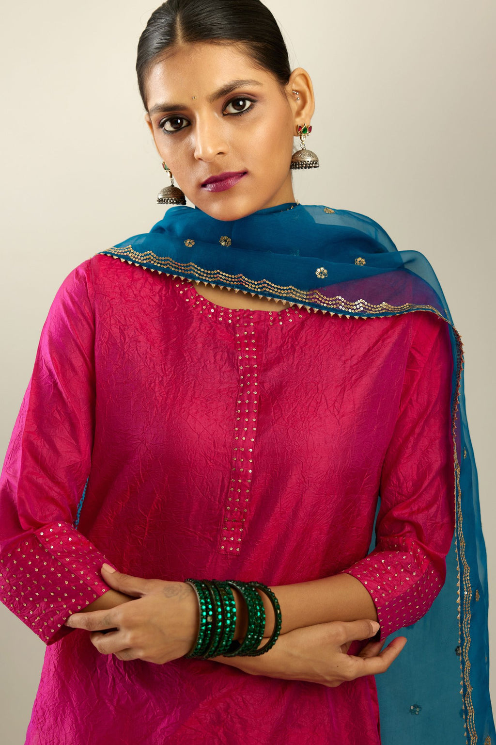 Raspberry silk hand crushed kurta set with concealed button placket neckline, highlighted with gold sequins.