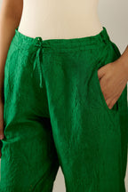 Grass green hand crushed pure silk straight pants with assorted diamond shape golden sequins work till knee length and side pockets.