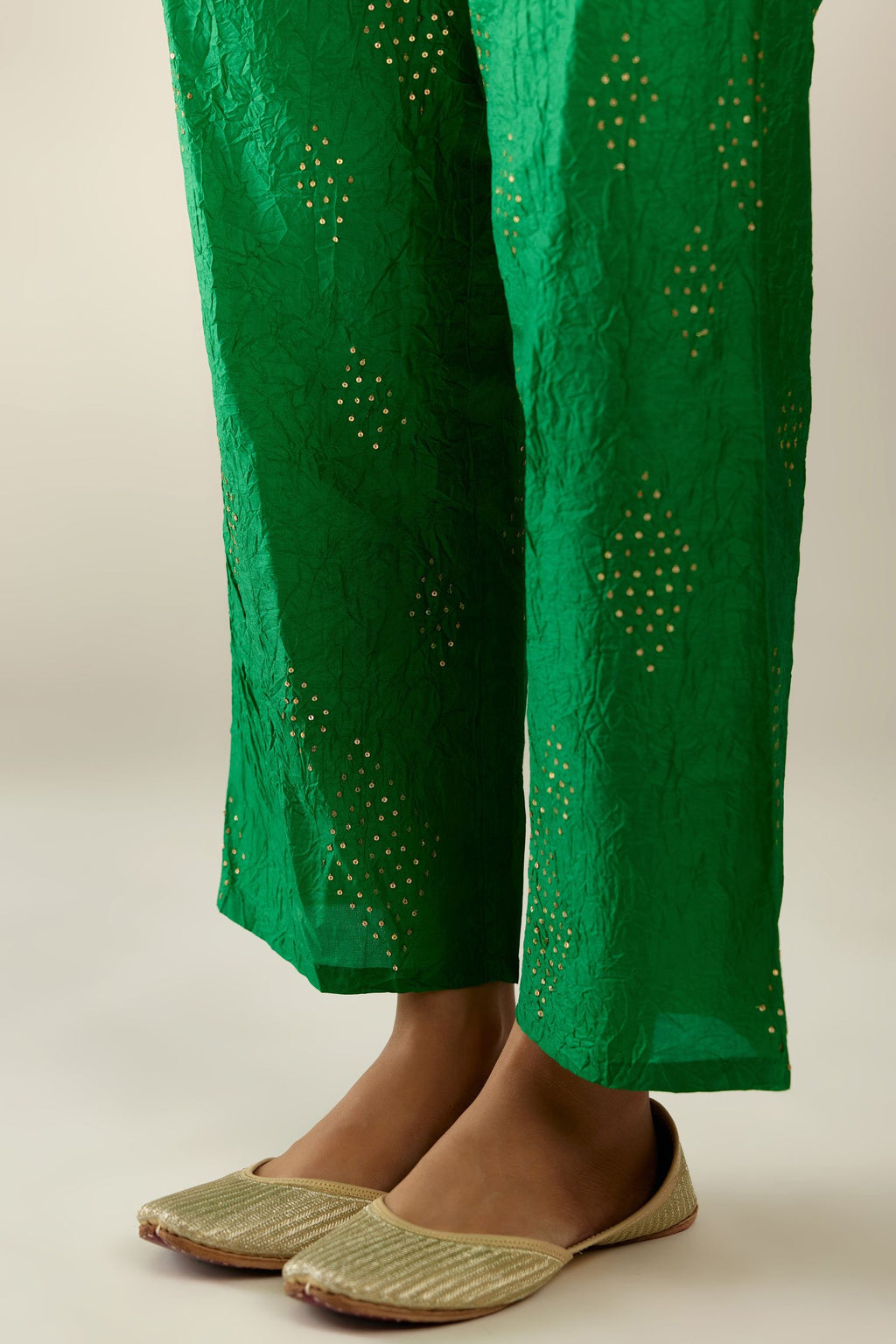 Grass green hand crushed pure silk straight pants with assorted diamond shape golden sequins work till knee length and side pockets.