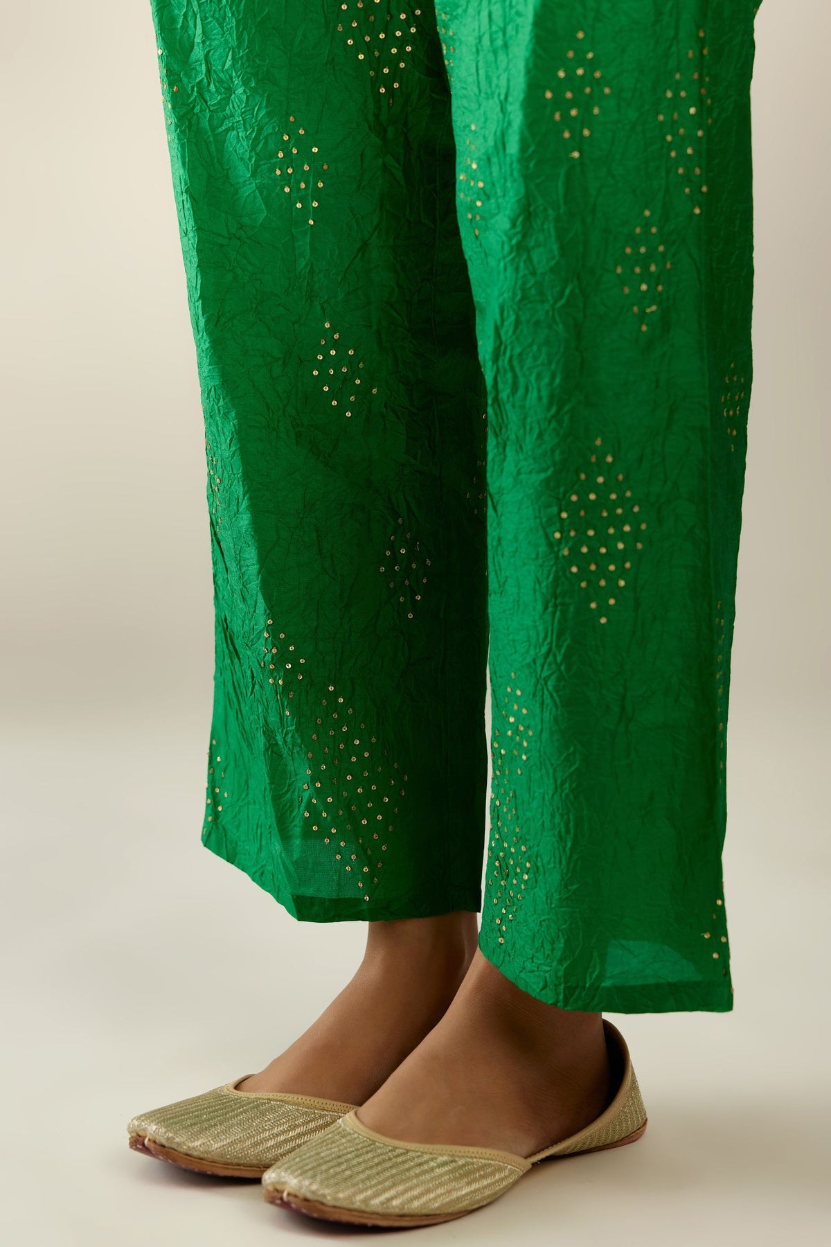 Grass green hand crushed pure silk straight pants with assorted diamond shape golden sequins work till knee length and side pockets.