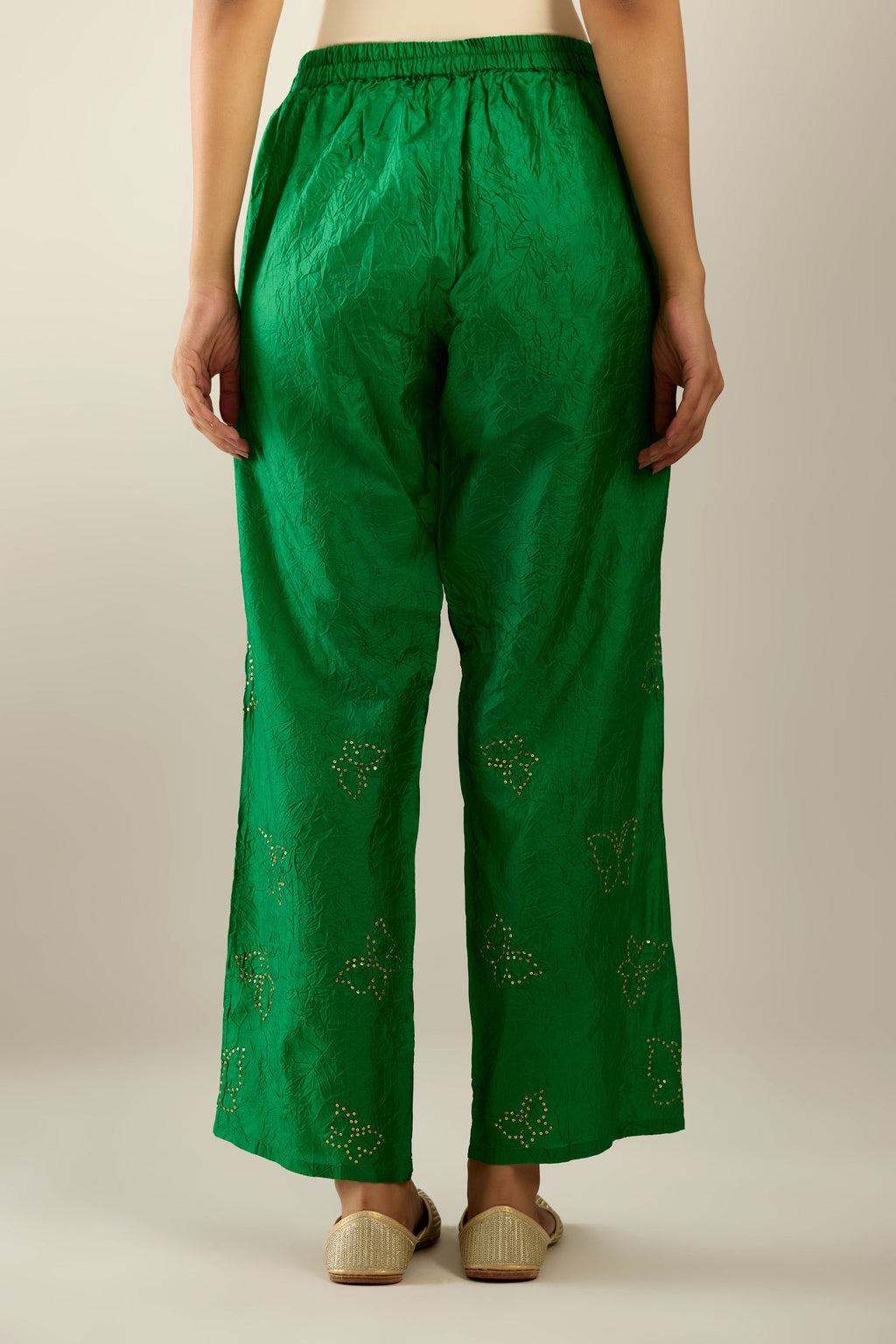 Grass green crushed silk pants with side pockets and assorted sequined butterflies till mid-calf length.