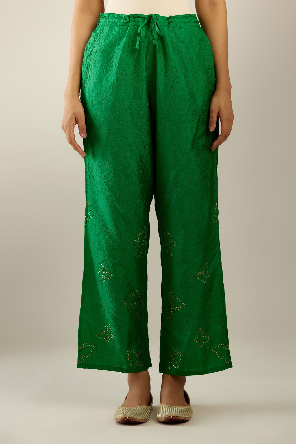 Grass green crushed silk pants with side pockets and assorted sequined butterflies till mid-calf length.