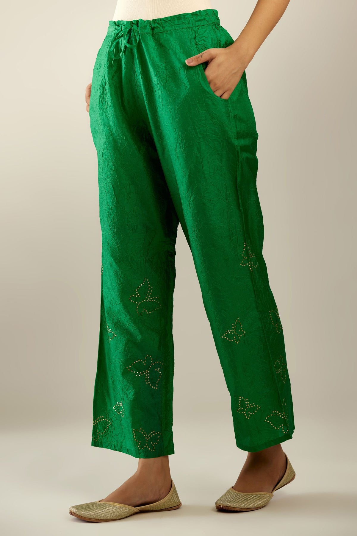 Grass green crushed silk pants with side pockets and assorted sequined butterflies till mid-calf length.