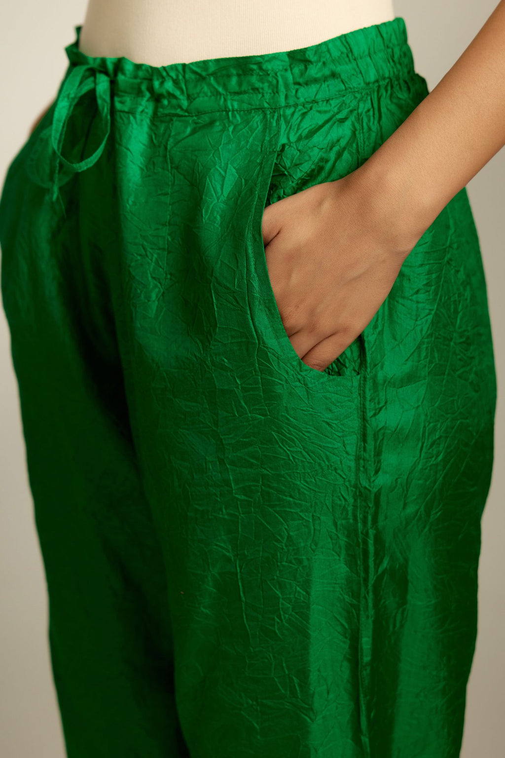 Grass green crushed silk pants with side pockets and assorted sequined butterflies till mid-calf length.