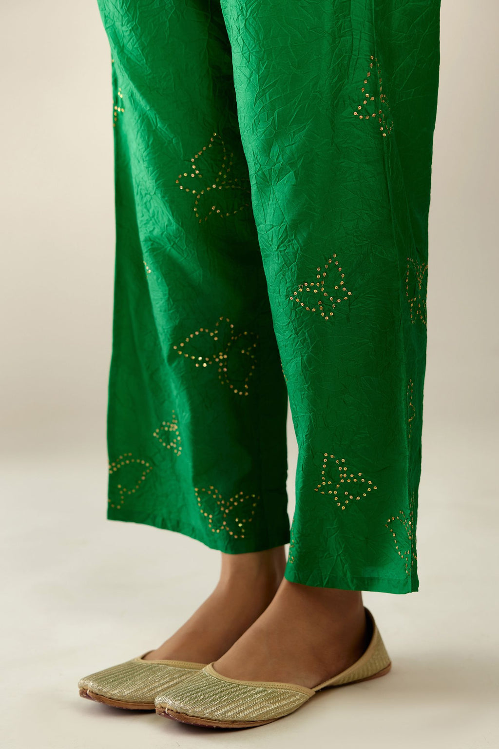 Grass green crushed silk pants with side pockets and assorted sequined butterflies till mid-calf length.