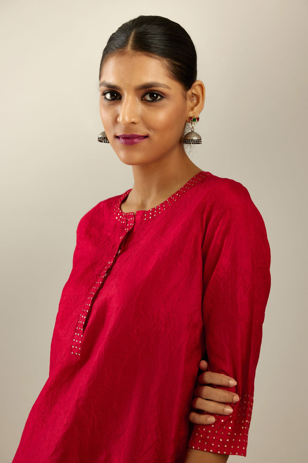 Red silk hand crushed kurta set with concealed button placket neckline, highlighted with gold sequins.