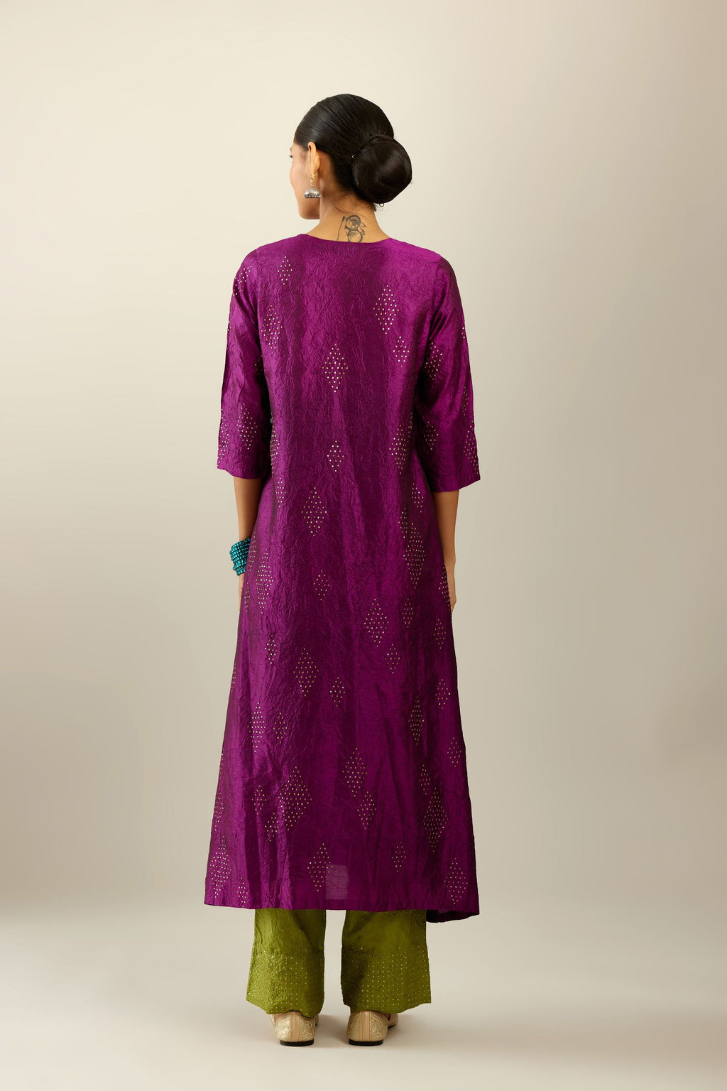Sangria silk hand crushed A-line kurta set with asymmetric hem, highlighted with all-over gold sequins diamonds.